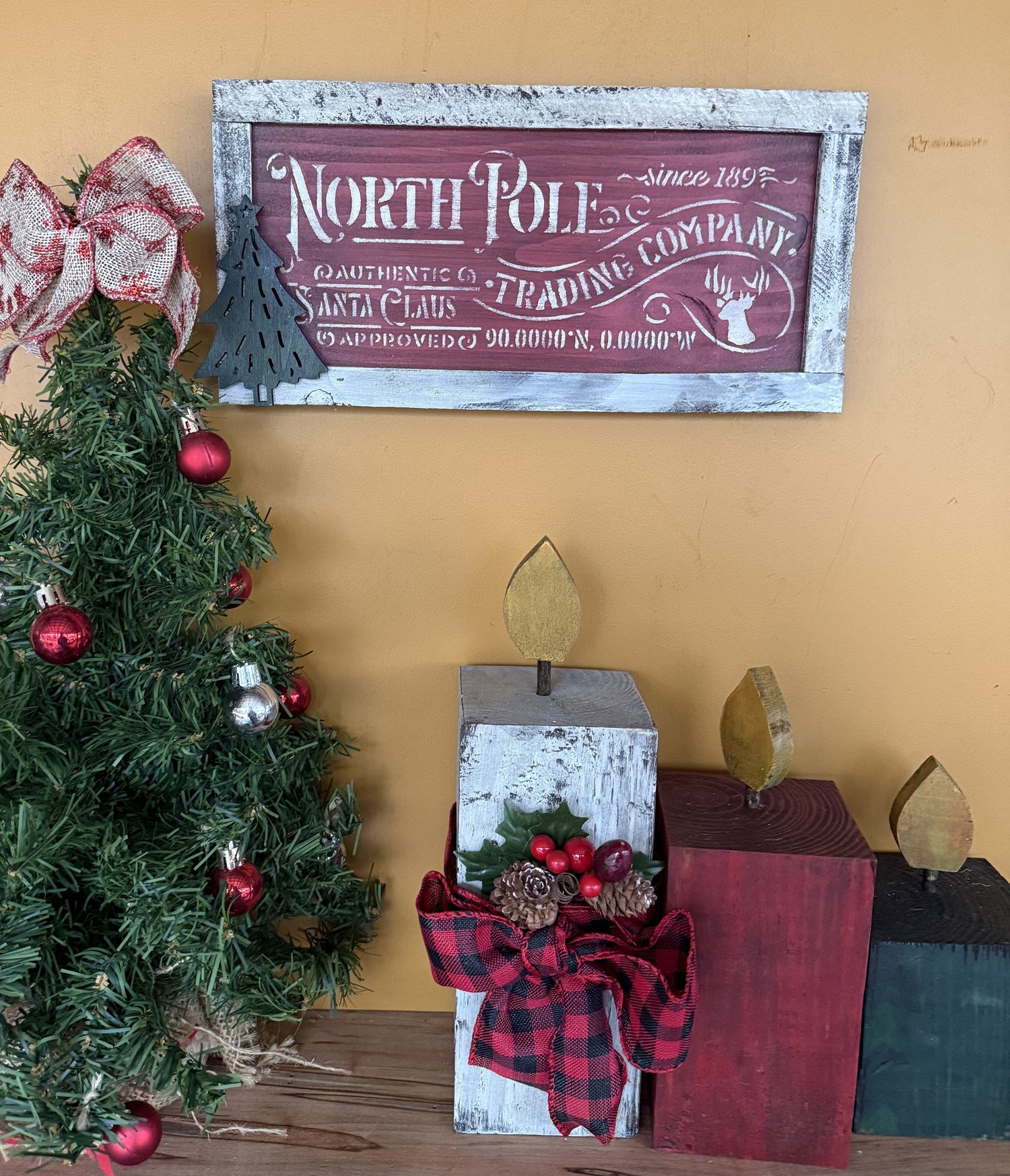 Decorative sign with 'North Pole Trading Company' text, surrounded by Christmas decorations.