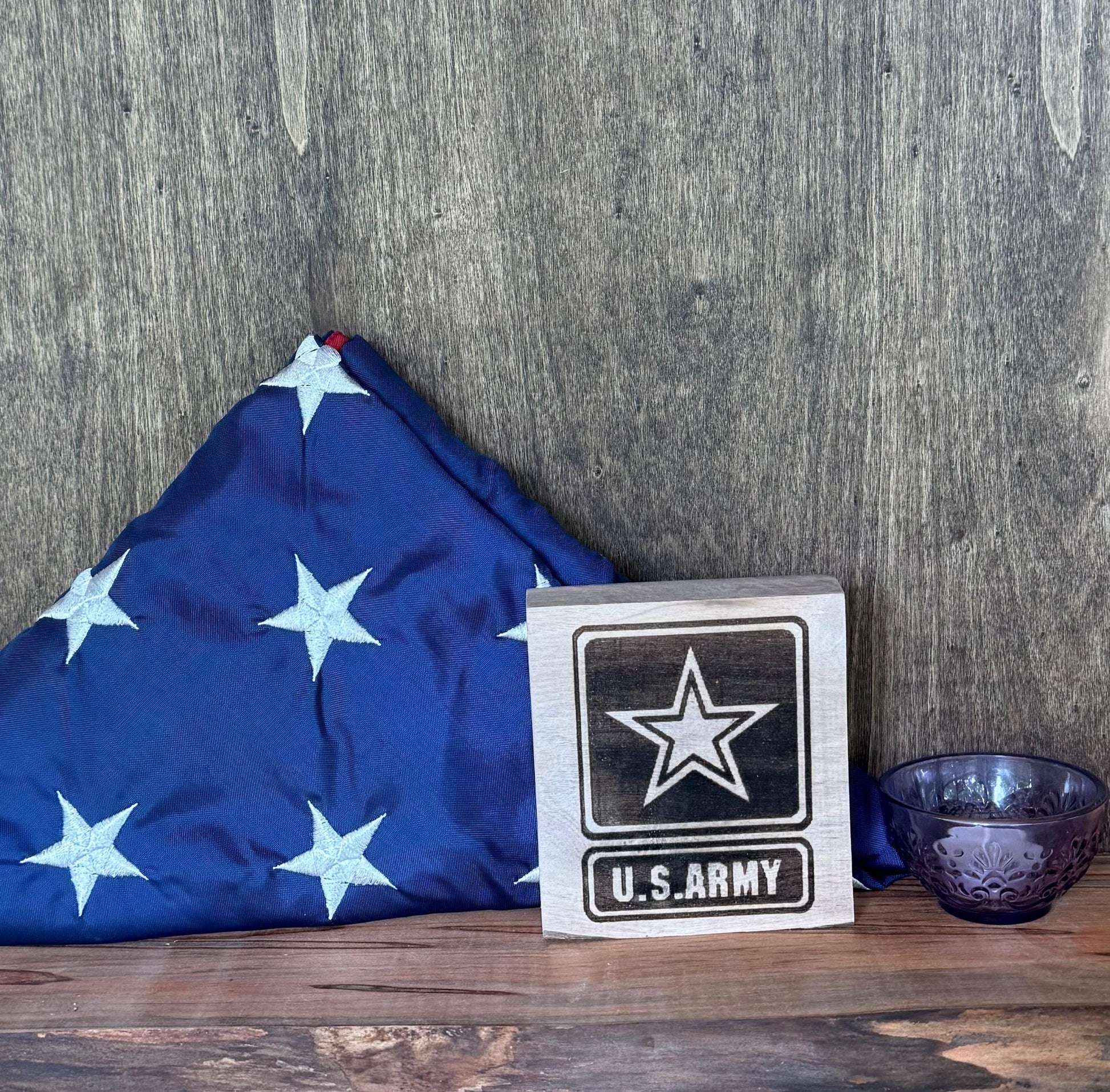 U.S. Army flag and emblem on a wooden surface with a wooden background
