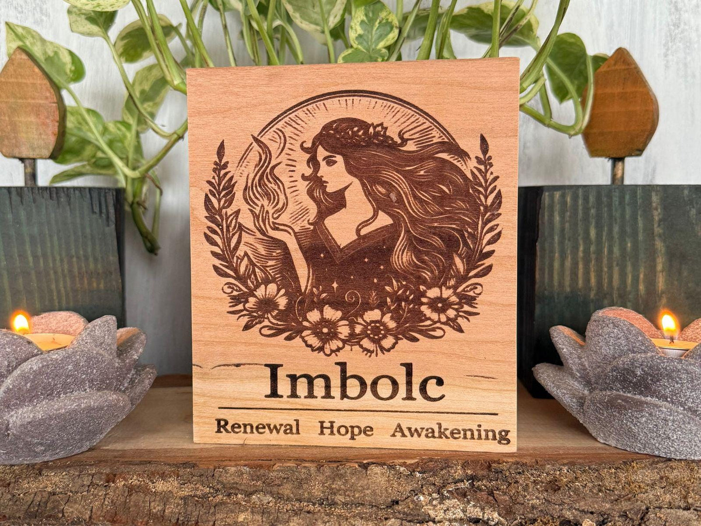 Wooden plaque with engraved design and text 'Imbolc Renewal Hope Awakening' on a decorative background.