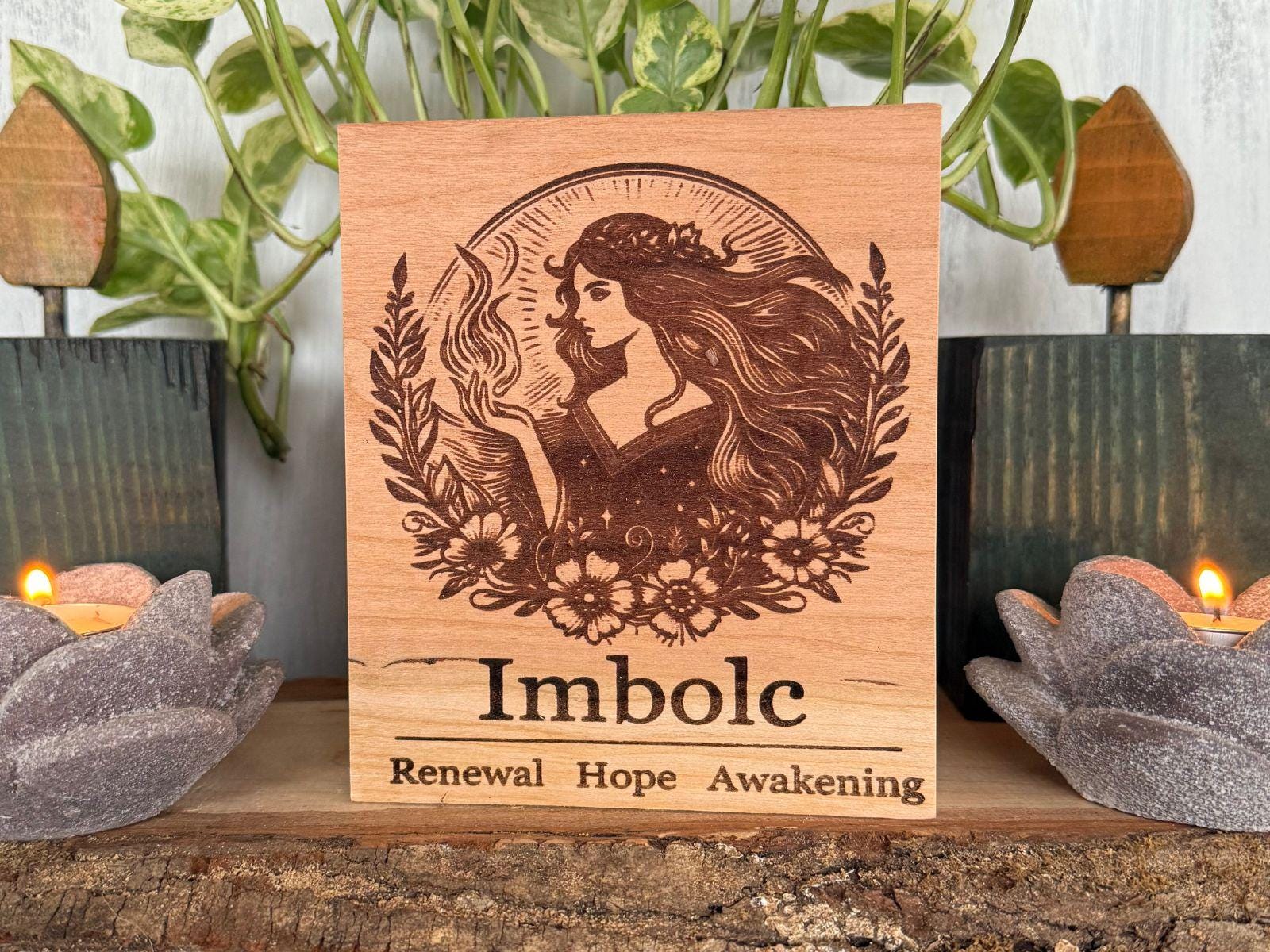 Wooden plaque with engraved design and text 'Imbolc Renewal Hope Awakening' on a decorative background.