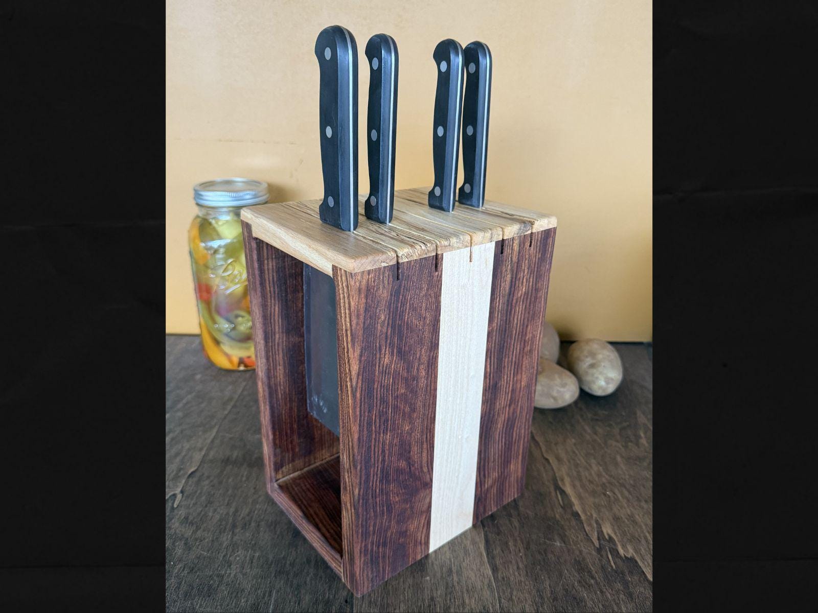 Wooden knife block with four knives on a countertop