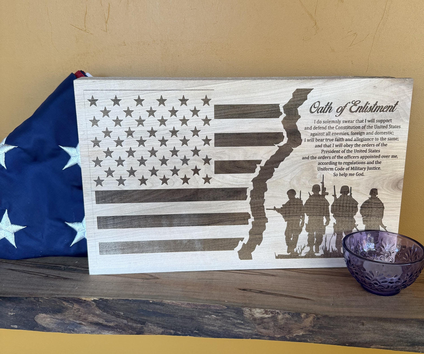 Wooden plaque with American flag design and silhouette of soldiers, featuring text of Oath of Enlistment.