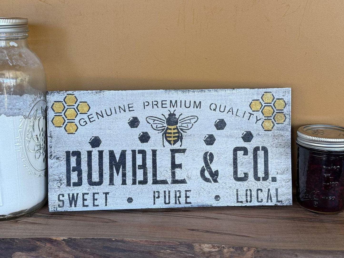 Wooden sign with 'Bumble & Co.' branding on a wooden shelf with jars.