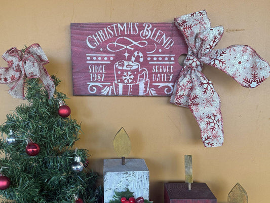 Decorative Christmas sign with red bows and a tree on a yellow wall