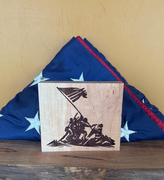 Wooden block with Iwo Jima Memorial design on a folded American flag background