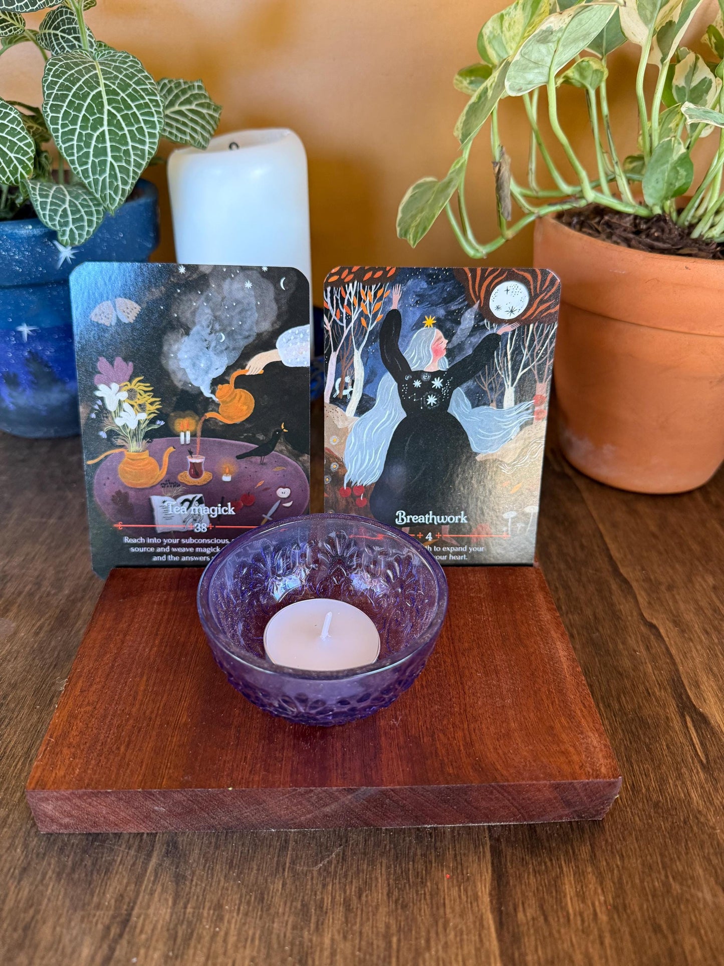 Two oracle cards and a candle on a wooden stand