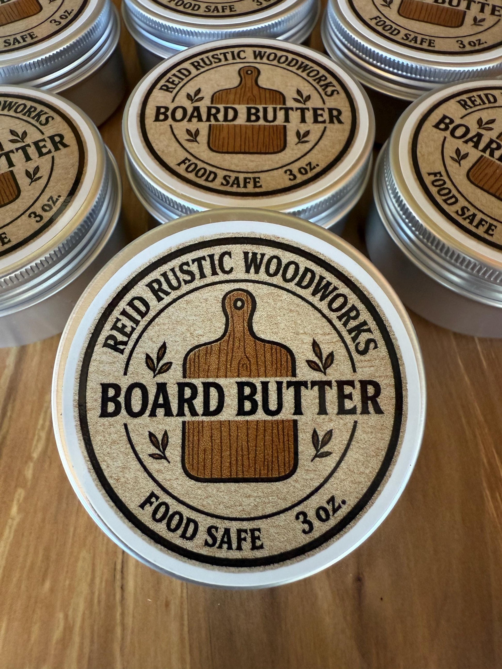 Jars of Reid Rustic Woodworks Board Butter on a wooden surface