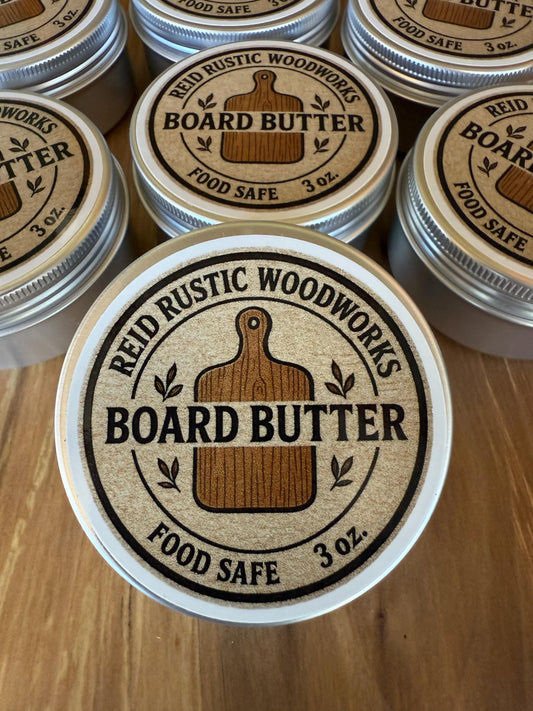 Jars of Reid Rustic Woodworks Board Butter on a wooden surface