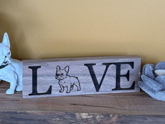 Wooden sign with 'LOVE' and a French bulldog illustration on a wooden surface.