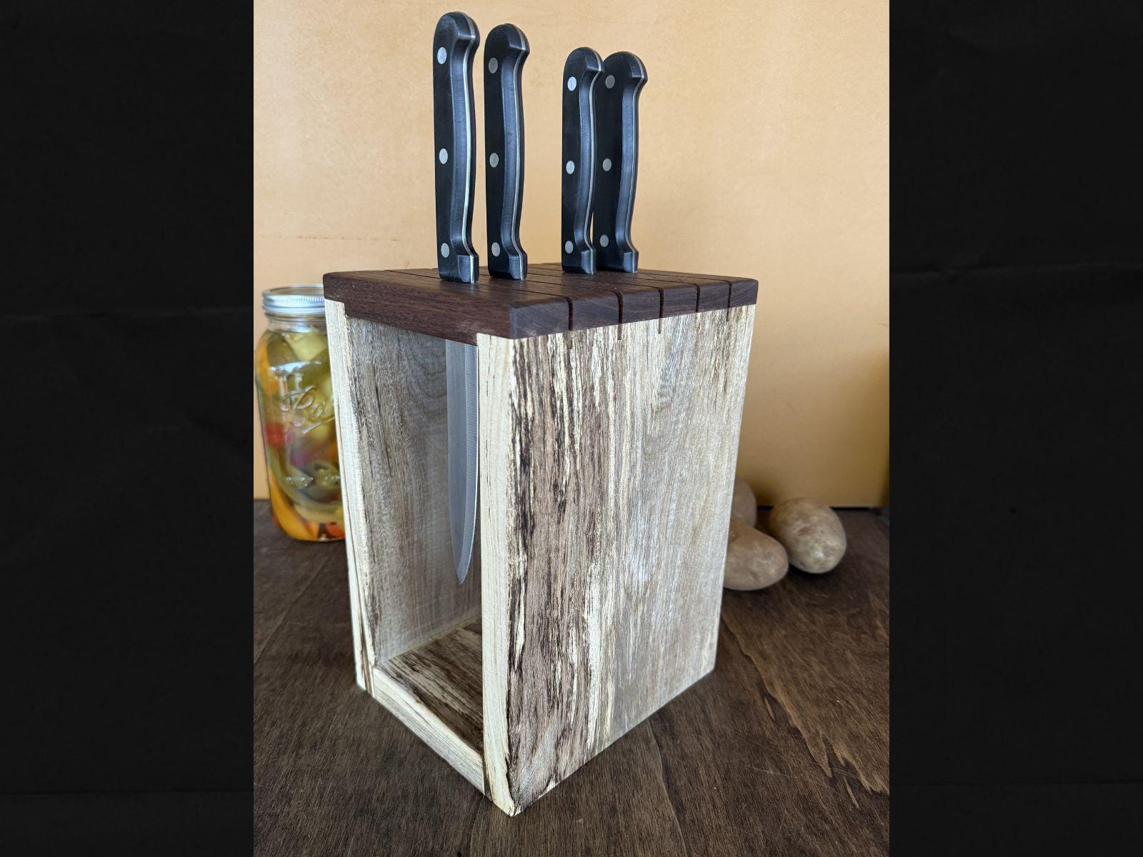 Wooden knife block with three knives on a wooden surface