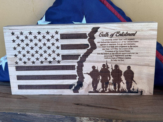 Wooden plaque with American flag design and silhouette of soldiers, featuring text of Oath of Enlistment.